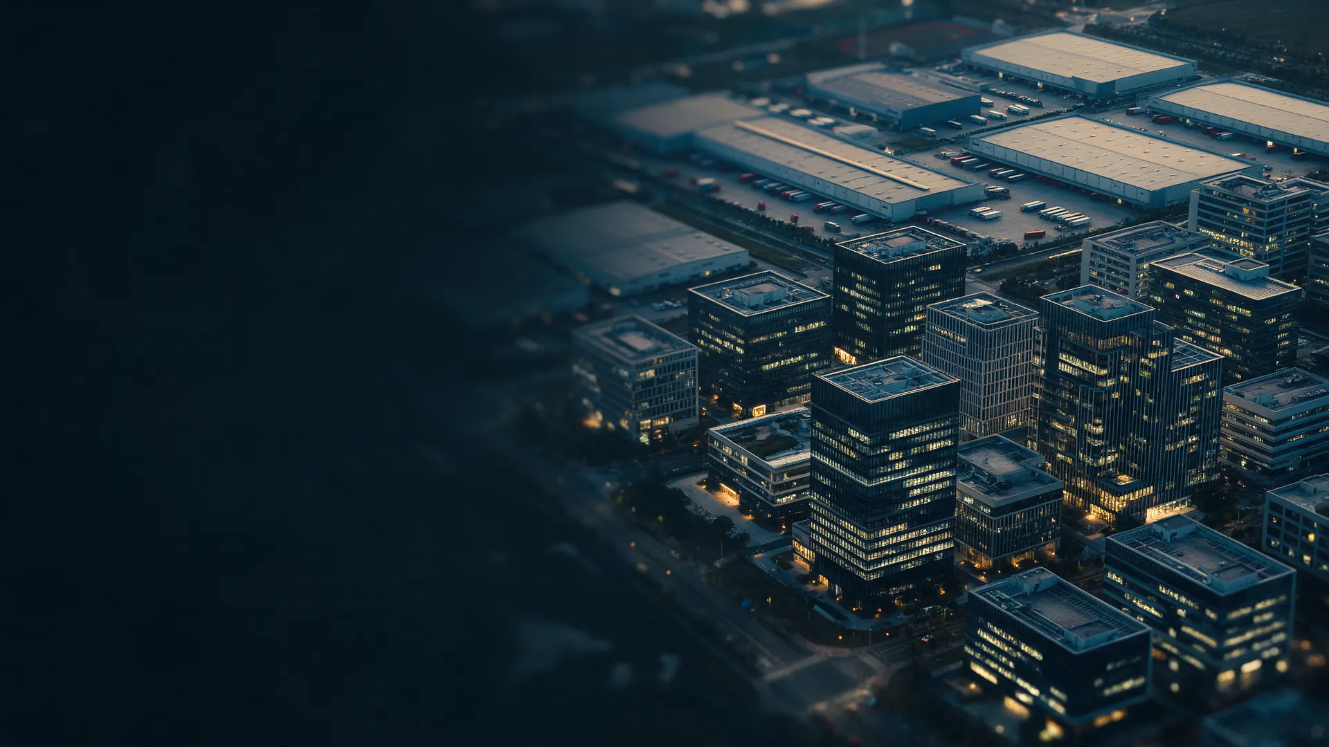 Office buildings and warehouses lit up at dusk